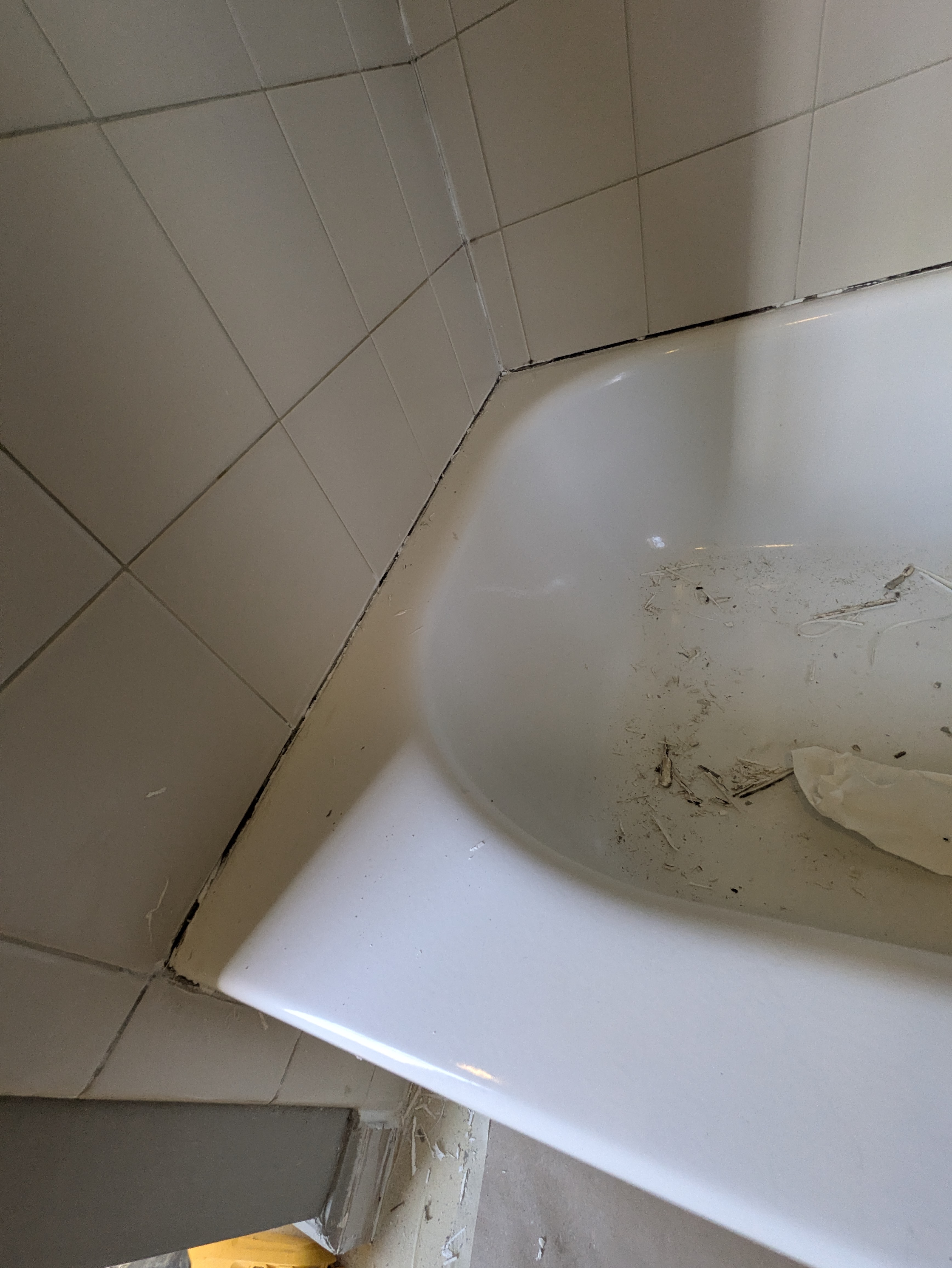 Detailed view of bathtub corner installation and caulking